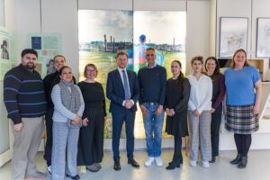 Der Sächsische Ministerpräsident Michael Kretschmer, der Vorsitzende und das Team von Romano Sumnal - Roma und Sinti Sachsen e. V. stehen nebeneinander und schauen in die Kamera